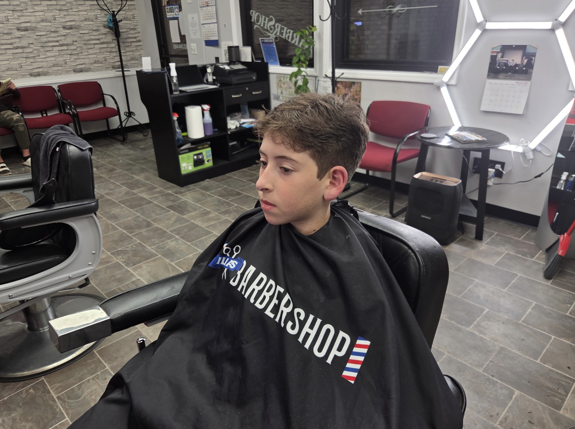 Young client getting a fresh haircut at Ilia's Barbershop